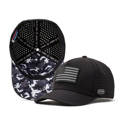 Black performance hat with a silver American flag logo on the front and a breathable black and grey camo mesh back, designed for outdoor activities and athletic performance.