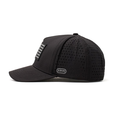 Side view of a black performance hat featuring a silver American flag logo, sleek contours, and perforated panels for enhanced breathability.