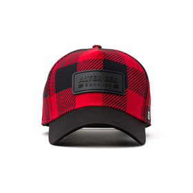Front view of a buffalo plaid hat featuring a black leather patch logo and insulated fabric, offering style and warmth for winter activities.