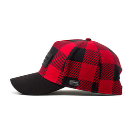 Side view of a red and black buffalo plaid insulated hat with a curved brim, perfect for outdoor adventures in cooler climates.