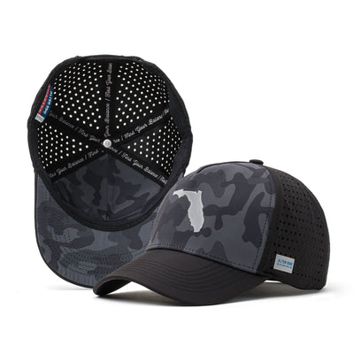 Black performance hat with a dark camo design and a black American flag patch on the front, paired with a breathable perforated mesh back for outdoor and athletic activities.