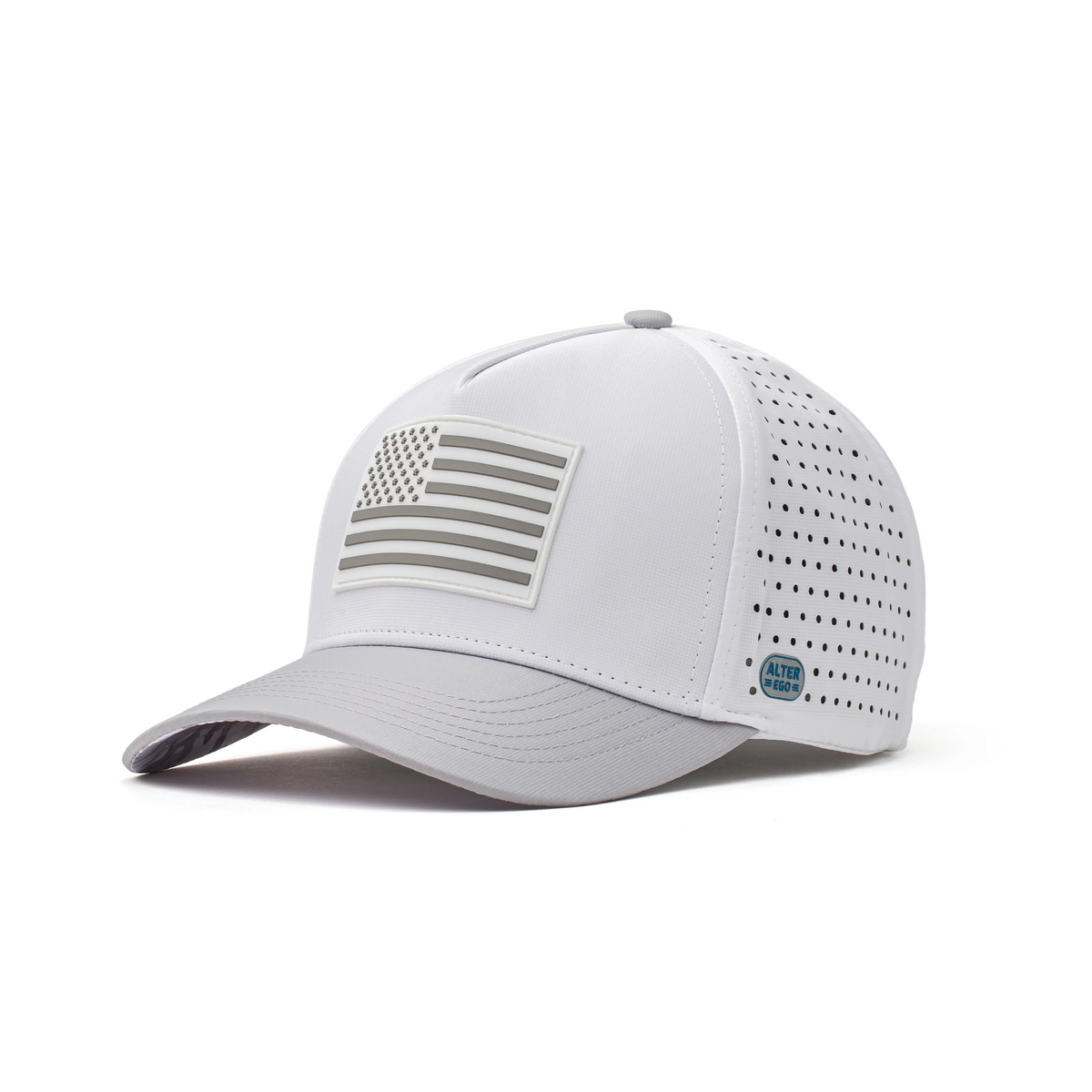Three-quarter view of the Coaster Splash Glacier White Silver Flag performance hat featuring a raised silver American flag patch, curved brim, laser-cut ventilation panels, and tonal side badge.