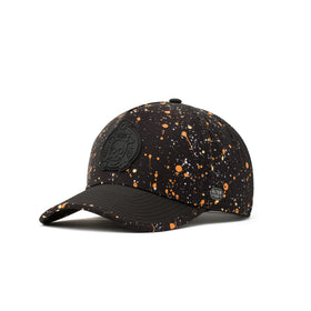Alter Ego Coaster Splash Dark Splatter hat shown from a three quarter angle, featuring a black base with orange and white splatter detailing, black brim, laser cut ventilation panels, black skull and crossbones patch, and reflective Alter Ego logo patch.