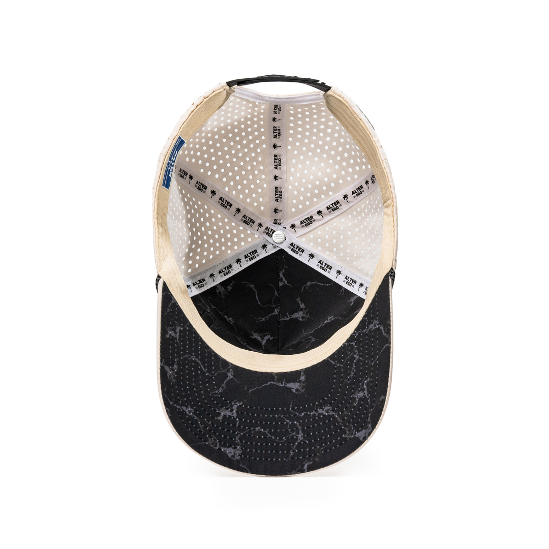 Alter Ego Coaster Splash Ivory Mummy hat featuring a black marble-inspired underbill, breathable laser-cut panels, and an adjustable snapback closure.