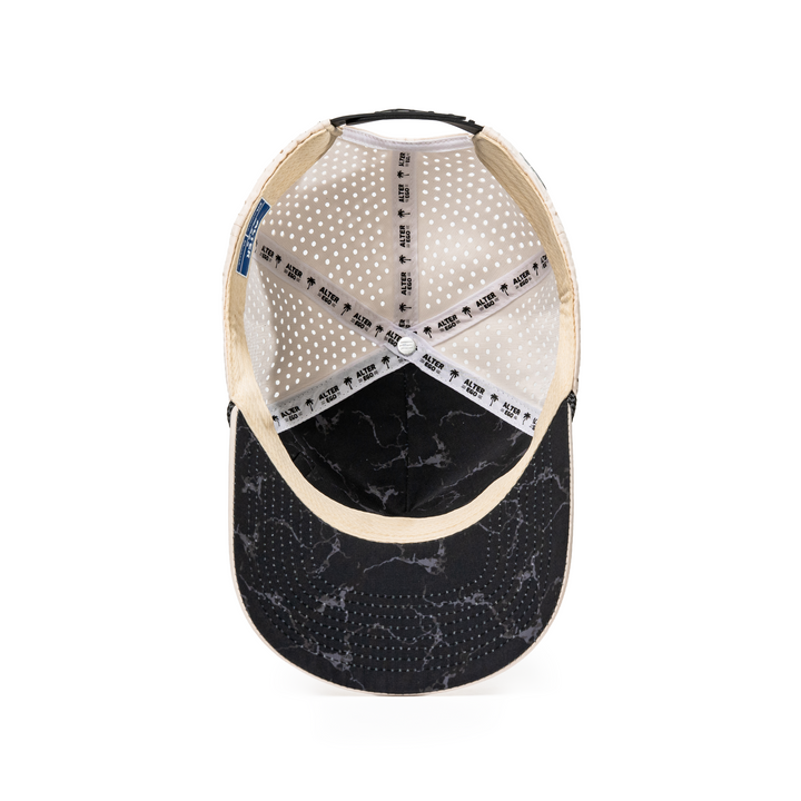 Alter Ego Coaster Splash Ivory Mummy hat featuring a black marble-inspired underbill, breathable laser-cut panels, and an adjustable snapback closure.
