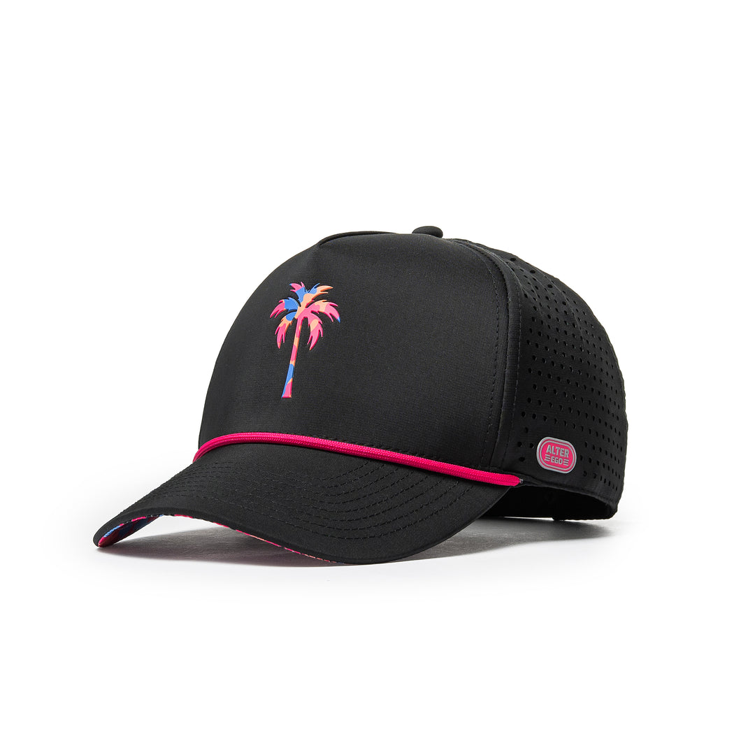 Alter Ego Coaster Splash Tropic Night Camo Palm black running hat with a colorful palm tree graphic, pink cord detail, laser-cut side panels, and reflective Alter Ego branding patch, shown from a front three-quarter view.