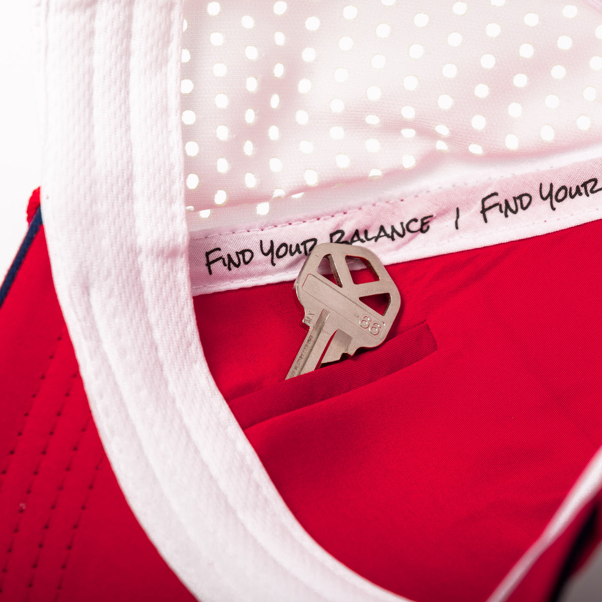 Close-up interior view of the Coaster Splash White USA Flag hat featuring a hidden storage pocket, "Find Your Balance" seam tape, moisture-wicking sweatband, and red interior lining.
